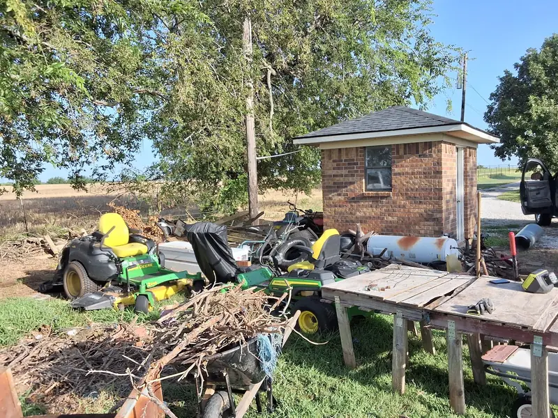 Brush, old mowers and scrap piled for removal before cleanup