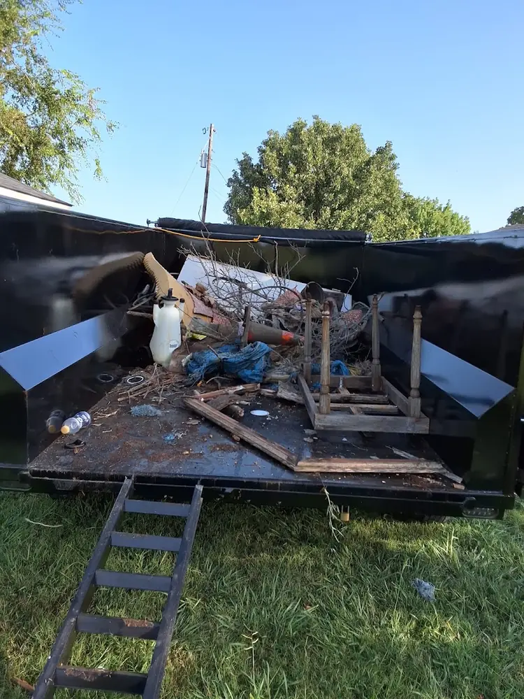 Dump trailer loaded with furniture and debris, ready to haul