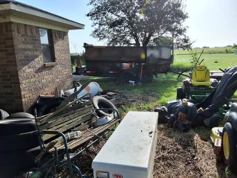 Dump trailer on site during a backyard junk removal job