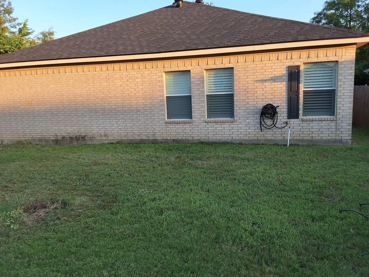 Clean swept yard and brick exterior after a full property cleanup